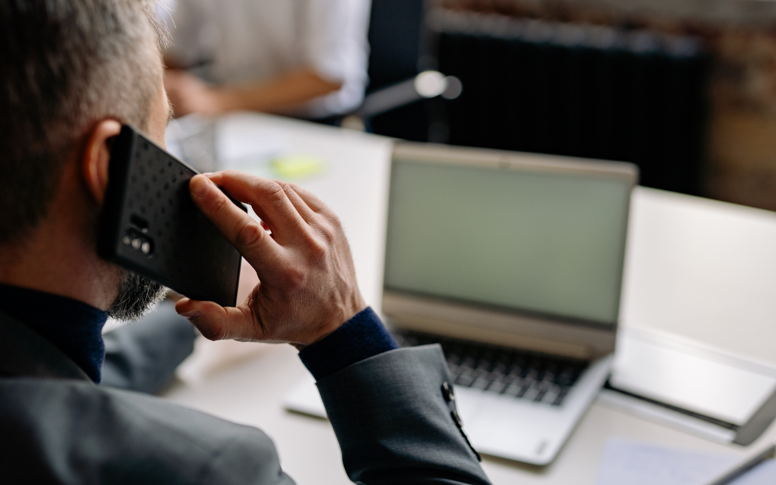 Business owner taking a phone call beside a laptop