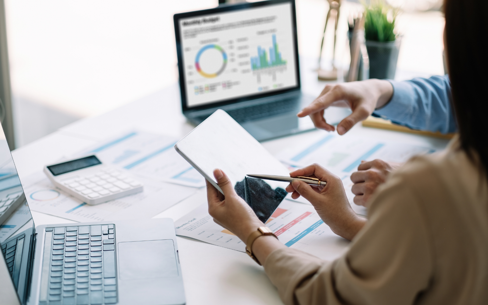 People reviewing business charts on a laptop and tablet